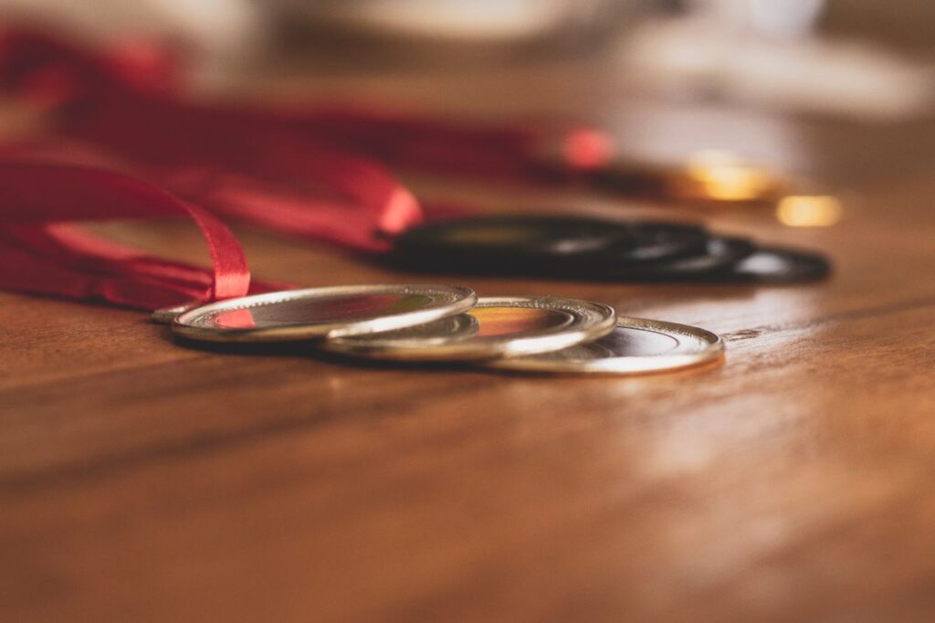 Close-up view of medals on a wooden table, showcasing bronze, silver, and gold awards.
